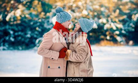 Coppia d'inverno che si gode una giornata di neve nel parco con vestiti caldi Foto Stock