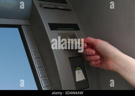 Donna con carta di credito che usa un moderno bancomat, primo piano. BANCOMAT Foto Stock