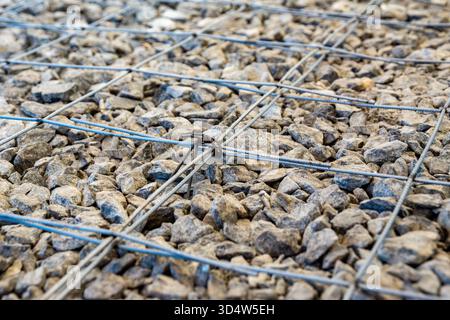 La griglia di barre di acciaio legate tra loro crea una resistenza alla trazione nel calcestruzzo per resistere alle sollecitazioni ed evitare cedimenti strutturali nel tempo messa a fuoco selettiva Foto Stock