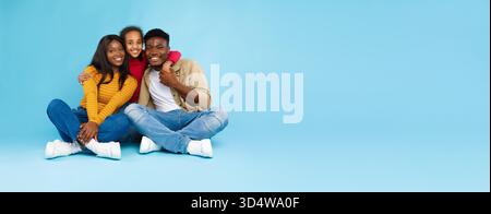 Famiglia felice che condivide momenti di gioia su sfondo blu Foto Stock