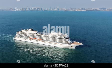 QINGDAO, CINA - 12 NOVEMBRE 2025 - la prima nave da crociera di lusso a cinque stelle della Cina con bandiera rossa, LA ZHAO SHANG YI DUN, la nave da crociera parte dalla baia di Jiaozhou verso il mare aperto a Qingdao, provincia di Shandong, Cina, il 12 novembre 2025. Foto Stock