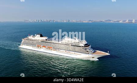 QINGDAO, CINA - 12 NOVEMBRE 2025 - la prima nave da crociera di lusso a cinque stelle della Cina con bandiera rossa, LA ZHAO SHANG YI DUN, la nave da crociera parte dalla baia di Jiaozhou verso il mare aperto a Qingdao, provincia di Shandong, Cina, il 12 novembre 2025. Foto Stock