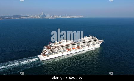QINGDAO, CINA - 12 NOVEMBRE 2025 - la prima nave da crociera di lusso a cinque stelle della Cina con bandiera rossa, LA ZHAO SHANG YI DUN, la nave da crociera parte dalla baia di Jiaozhou verso il mare aperto a Qingdao, provincia di Shandong, Cina, il 12 novembre 2025. Foto Stock