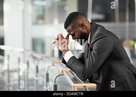 Sopraffatti uomo d'affari nero sensazione giù dopo riunione di affari Foto Stock