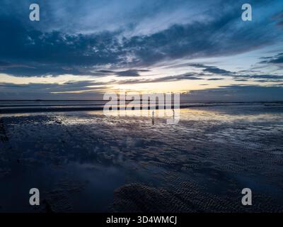 Due persone sagomate al tramonto, Hilbre Island, West Kirby, Wirral, Inghilterra Foto Stock