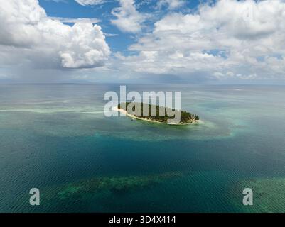 Isola tropicale coperta da alte palme da cocco e circondata da spiaggia sabbiosa e mare cristallino. Siargao, Filippine. Casa desiderio. Foto Stock