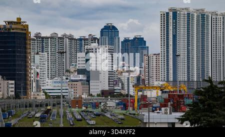 BUSAN, COREA DEL SUD - 9 OTTOBRE 2025 - Busan, paesaggio urbano della Corea del Sud caratterizzato da alti edifici e un trafficato porto marittimo Foto Stock