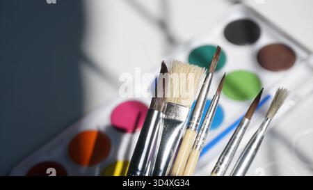 Pennelli e vernici ad acquerello su un tavolo in uno studio Foto Stock