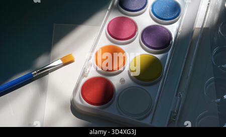 Colori e pennelli ad acquerello su sfondo bianco, primo piano Foto Stock