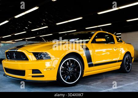 2013 Ford Mustang Boss 302 Laguna Seca Edition in School Bus Yellow, strisce nere. Auto muscolare di produzione limitata in garage. Niente persone. Foto Stock