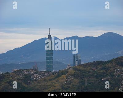 Taipei, Taiwan - 14 novembre 2024: Vista ravvicinata del grattacielo Taipei 101 che si innalza sopra le montagne, visto da Maokong. Foto Stock