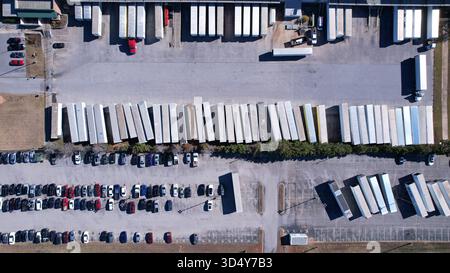 Rimorchi chiusi parcheggiati ordinatamente in un'area di produzione dalla vista aerea dall'alto verso il basso Foto Stock