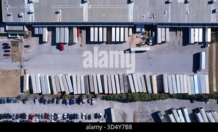Rimorchi chiusi parcheggiati ordinatamente in un'area di produzione dalla vista aerea dall'alto verso il basso Foto Stock