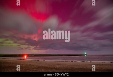 L'aurora boreale (Aurora Boreale) sopra il molo di Berwick e il faro che mostrano sopra le nuvole nelle prime ore del 12 novembre 2025 Foto Stock