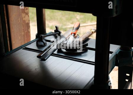 Utensili manuali assortiti su banco da lavoro in metallo in officina Foto Stock