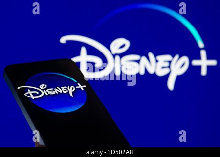 Bruxelles, Belgio. 12 novembre 2025. Il logo Disney Plus viene visualizzato su un telefono cellulare con il marchio dell'azienda visibile sullo sfondo, in questa illustrazione fotografica a Bruxelles, Belgio, il 12 novembre 2025. (Foto illustrazione di Jonathan RAA/NurPhoto) crediti: NurPhoto SRL/Alamy Live News Foto Stock