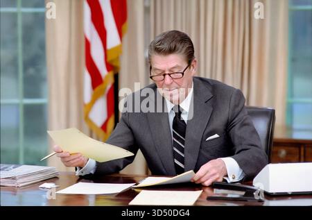 Il Presidente degli Stati Uniti Ronald Reagan il primo giorno di amministrazione presso Oval Office, Casa Bianca, Washington, D.C., USA, Presidente Ronald Reagan White House Photographic Office, 21 gennaio 1981 Foto Stock