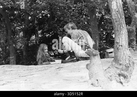 Uomo e donna che rilassano giovane e giovane donna che si rilassano e ricreano all'interno delle dune di forrest la domenica pomeriggio. Loon op Zand, Paesi Bassi. Girato su Analog Black & White Film, 1994. Loon op Zand Loonse & Drunense Duinen Noord-Brabant Nederland Copyright: XGuidoxKoppesxPhotox Foto Stock