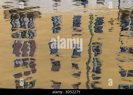 riflessi dell'edificio distorti sulla superficie d'acqua increspata Foto Stock