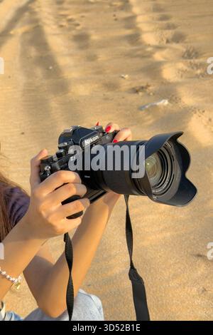 Doha, Qatar - : Nikon ZF Mirrorless camera - ragazza che tiene in mano una fotocamera Nikon ZF full-frame ispirata al retro Foto Stock