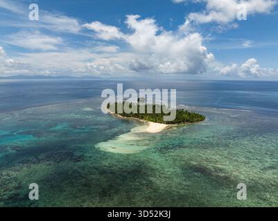 Una piccola isola tropicale coperta da palme e' circondata da acque turchesi e barriera corallina con una spiaggia di sabbia bianca. Siargao, Filippine. Isola di Kawhagan. Foto Stock