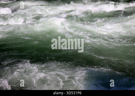 primo piano di superficie d'acqua in un fiume che scorre veloce con le onde Foto Stock