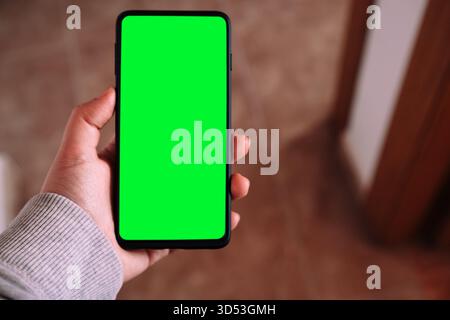 Donna che tiene a mano lo smartphone con schermo verde per il mockup. Concetto del modello di progettazione del sito Web UX/ui. Foto Stock