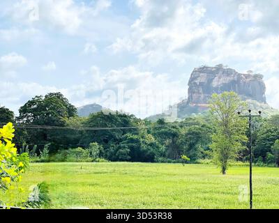 Storica fortezza di Sigiriya nello Sri Lanka sotto il cielo limpido, caratterizzata da suggestive pareti di roccia e ampie vedute verdi del paesaggio Foto Stock