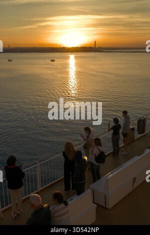 Persone che guardano il tramonto sul porto di Bari da una nave da Dubrovnik, Puglia, Italia Foto Stock