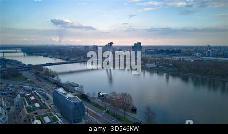 La vista aerea dell'iconico ponte SNP attraversa con grazia il fiume Danubio, collegando vivaci paesaggi urbani sotto un cielo morbido e diffuso, stare MES Foto Stock