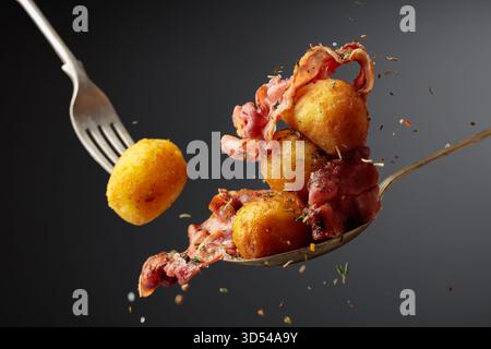 Patate arrosto con pancetta cosparsa di sale marino e miscela di erbe e spezie. Foto Stock