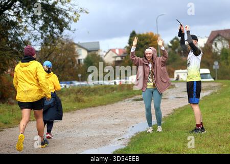 I tifosi amichevoli festeggiano dopo aver corso all'aperto su una pista bagnata durante la pioggia autunnale Foto Stock