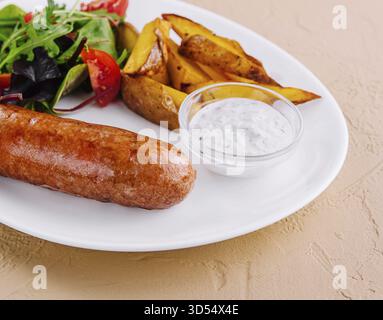Cibo, salsicce arrostite con patate al forno e insalata verde Foto Stock