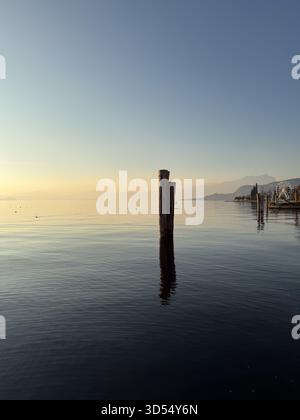 Luce del tramonto sulle acque tranquille del Lago di Garda, Italia Foto Stock