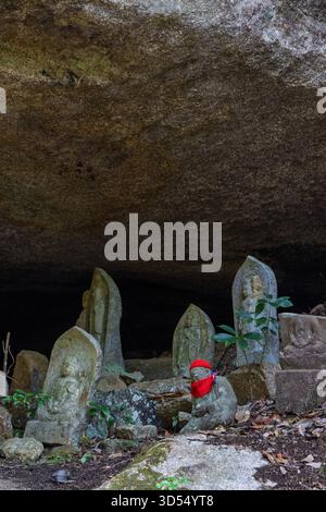 Grotta piena di piccole sculture di buddha lungo il sentiero a piedi fino alla cima del Monte Misam, sull'isola Miyajima Hatsukaichi, Giappone Foto Stock