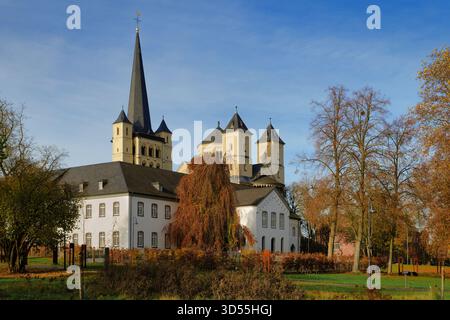 La storica Abbazia di Brauweiler vicino a Colonia, con la sua chiesa romanica con guglie e l'ala bianca barocca, circondata da colorate foglie autunnali Foto Stock