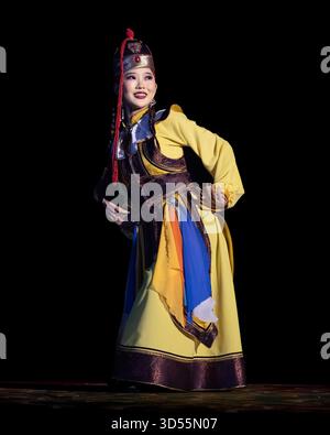 I membri del rinomato gruppo nazionale di arti dello spettacolo della Mongolia, il Tumen-Ekh Folk Song and Dance Ensemble, si esibiscono in costumi tradizionali mongoli. Foto Stock