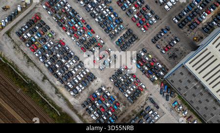 Una vista aerea mostra un ampio parcheggio con molti veicoli parcheggiati, un magazzino e terreni agricoli circostanti a U-pull-it York, Regno Unito. Foto Stock