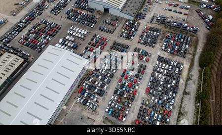 Vista aerea di un grande deposito auto all'aperto pieno di numerosi veicoli parcheggiati, diversi edifici e paesaggio circostante a U-Pull-IT York, U Foto Stock