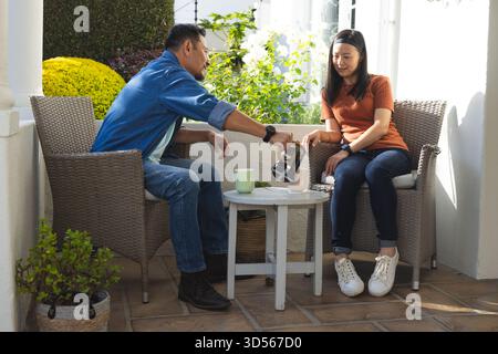 Coppia matura che si gusta un caffè sul patio, condividendo momenti di pace Foto Stock