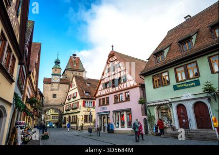 ROTHENBURG OB DER TAUBER, GERMANIA - 20 DICEMBRE 2024: Le persone passano per la strada di fronte alla Torre Markus a Rothenburg ob der Tauber, Germania Foto Stock