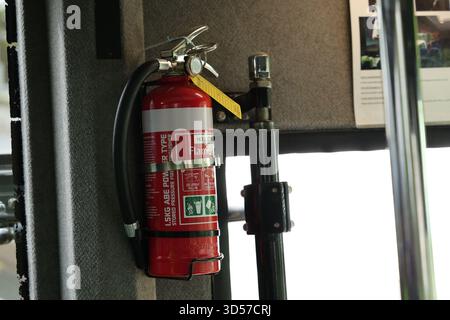 Estintore rosso all'interno del bus passeggeri Foto Stock