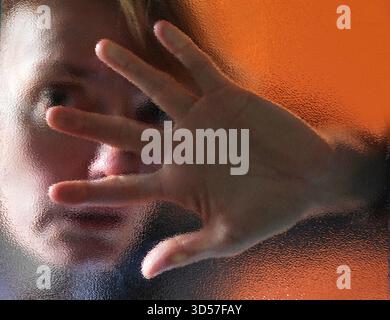 Frau hinter einer Glasscheibe model realase vorhanden GER, 20251030, Frau hinter einer Glasscheibe an einer Eingangstür *** donna dietro un pannello di vetro modello realase available GER, 20251030, donna dietro un pannello di vetro alla porta di ingresso M:RY Foto Stock