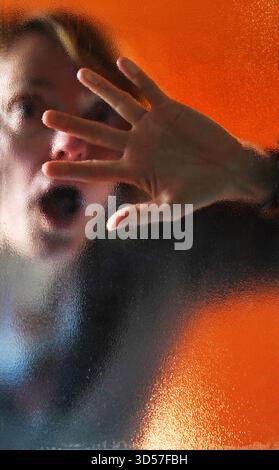 Frau hinter einer Glasscheibe model realase vorhanden GER, 20251030, Frau hinter einer Glasscheibe an einer Eingangstür *** donna dietro un pannello di vetro modello realase available GER, 20251030, donna dietro un pannello di vetro alla porta di ingresso M:RY Foto Stock