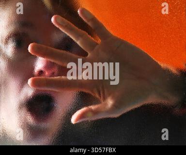 Frau hinter einer Glasscheibe model realase vorhanden GER, 20251030, Frau hinter einer Glasscheibe an einer Eingangstür *** donna dietro un pannello di vetro modello realase available GER, 20251030, donna dietro un pannello di vetro alla porta di ingresso M:RY Foto Stock