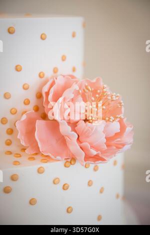 Elegante torta bianca con fiore di zucchero rosa Foto Stock