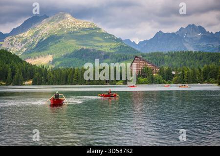 Štrbské pleso, alti Tatra SLOVACCHIA - 21 luglio 2019: Barche a remi rosse in barca sul lago Štrbské pleso, circondato dalle montagne degli alti Tatra. Foto Stock