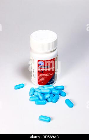 Bottiglia bianca di tappi Kroger acetaminofene PM con etichetta rossa circondata da pillole blu sparse su sfondo bianco Foto Stock