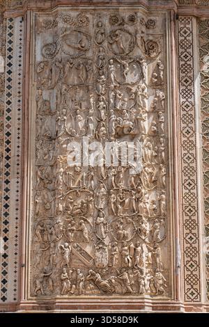 Italia - Orvieto - Duomo di Orvieto - dettaglio delle intricate sculture in pietra sulla facciata raffiguranti scene bibliche Foto Stock