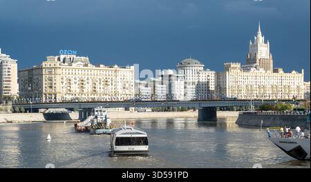 25 agosto 2025, Mosca, Russia. Il fiume riflette lo skyline di Mosca con un'architettura elegante, caratterizzata da barche che navigano sull'acqua e da un suggestivo clo Foto Stock